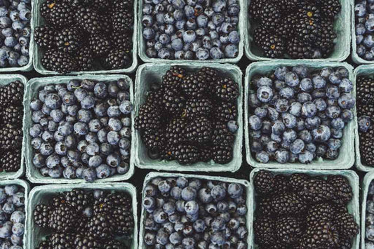 Fresh blueberries and blackberries in cartons, rich in antioxidants.