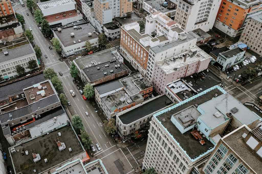 Aerial view of a dense urban neighborhood with buildings, streets, and minimal greenery.