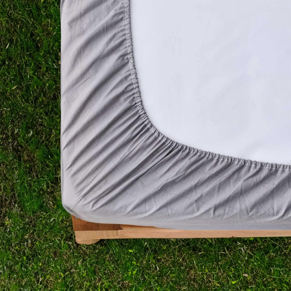 Close-up of Tala grounding sheet fitted corner showing soft, breathable fabric and elastic edge for a snug fit on any mattress.