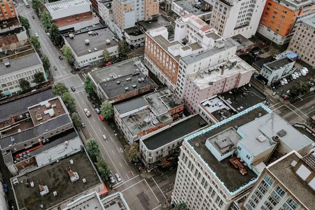 Aerial view of a dense urban neighborhood with buildings, streets, and minimal greenery.